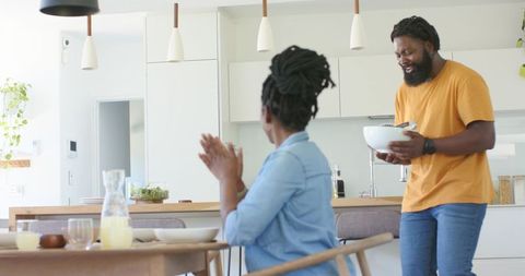 African American couple preparing breakfast together in bright modern minimalist kitchen