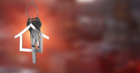 House-Shaped Keychain on Red Background Symbolizing Home Ownership