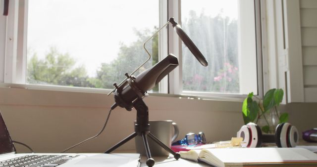 Desktop podcasting microphone with open notebook by window capturing natural light - Download Free Stock Images Pikwizard.com