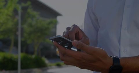 Businessman Holding Smartphone Checking Messages Outdoors