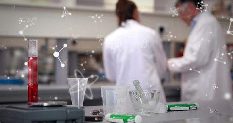 Scientists conducting laboratory research on benchtop with red test tube mortar and pipettes