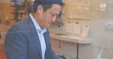 Professional Man Typing on Laptop in Cafe for Business Work