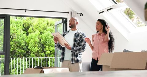 Couple Unpacking Boxes in New Sunlit Home Interior