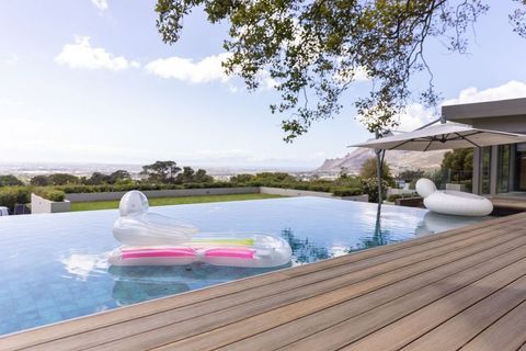 Translucent inflatable lounger floating in infinity pool with wooden deck and ocean view
