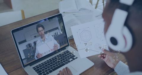 Designer collaborating remotely via video call with engineering plans