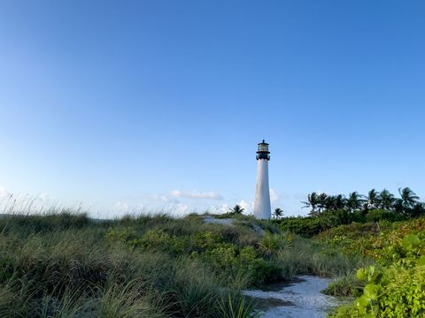 Lighthouse Towering Above Coastal Dunes on Clear Day