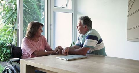 Senior Couple Holding Hands and Connecting at Table