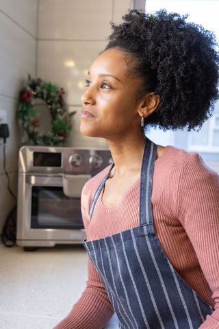 Sunlit African American Woman Preparing Holiday Baking in Kitchen Wearing Striped Apron