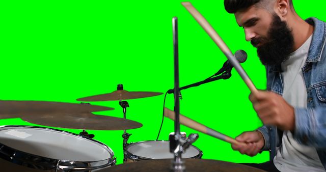 Drummer singing while playing drum against green screen