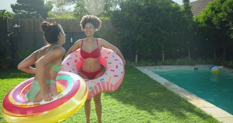 Diverse friends enjoying summertime with inflatable pool rings