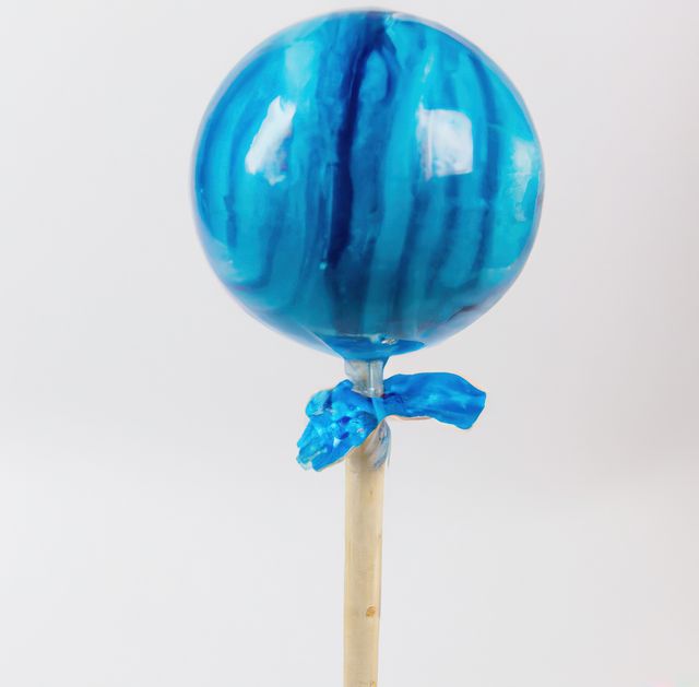 Close up of round blue lollipop on white background. Candy, sweets, food and drink concept.