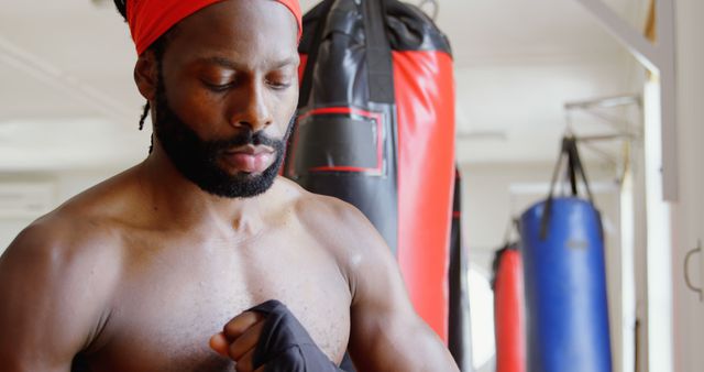 Focused male athlete wrapping hands in gym - Download Free Stock Images Pikwizard.com