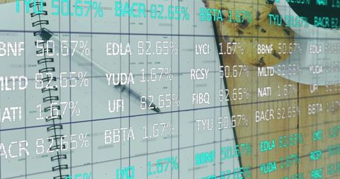 Spiral notebook with pen on wooden desk and stock ticker overlay for finance planning