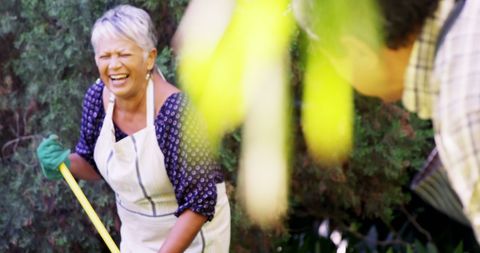 Joyful Middle-Aged Woman Enjoying Gardening with Laughter