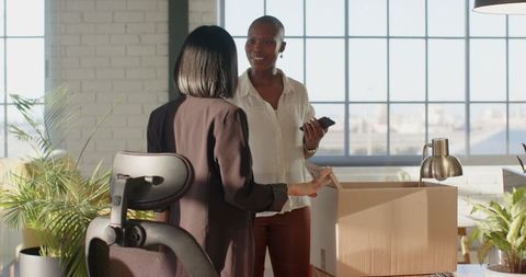 Businesswomen Unpacking Boxes in Studio Office Workspace