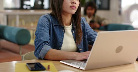 African american woman working on laptop in coworking cafe, focusing on productivity