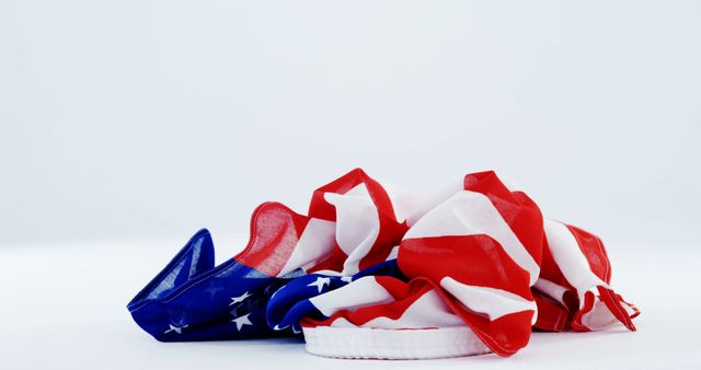 Crumpled United States flag symbolizing complexities of national pride. Suitable for articles on patriotism, American history, national debates, or creative editorial pieces.