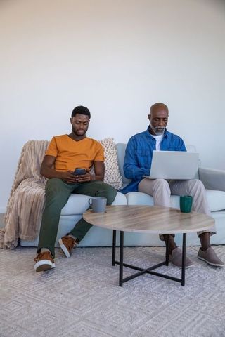 Father and Son Sharing Moment with Technology in Cozy Living Room