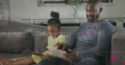 Father and daughter bonding on couch using tablet and smartphone with social overlays