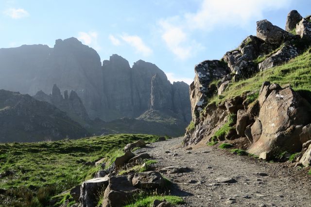 Mountain path winding through rocky terrain, ideal for promoting adventure tourism, travel destinations, hiking trails, and outdoor activities. Suitable for adventure magazines, tourism brochures, and environmental blogs.