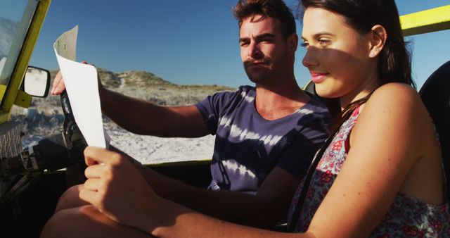 Couple navigating their way using a map during an off-road adventure in a beach buggy. Ideal for travel blogs, summer vacation promotions, adventure tourism advertisements, and outdoor activity websites.