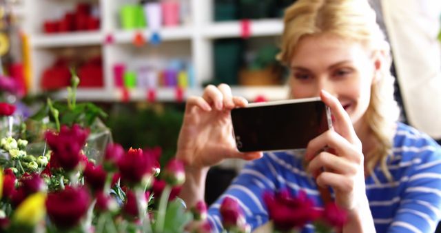 Woman taking photograph of flower bouquet in flower shop