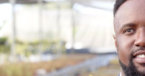 African American Man in Greenhouse Tunnel Environment with Soil