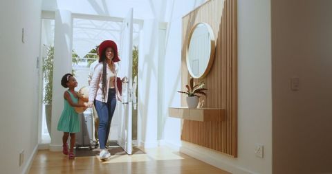 Happy Family Arriving in Bright Modern Home with Luggage
