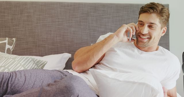 Casual Man Relaxing on Bed and Talking on Phone - Download Free Stock Images Pikwizard.com