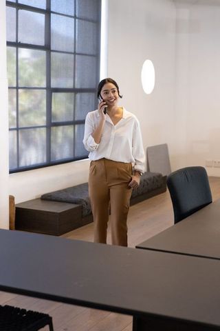 Confident Professional Holding Smartphone in Modern Minimalist Office