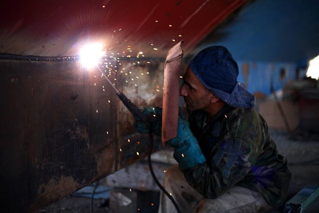 Welder Working Underneath Metal Structure With Sparks Flying - Download Free Stock Photos Pikwizard.com