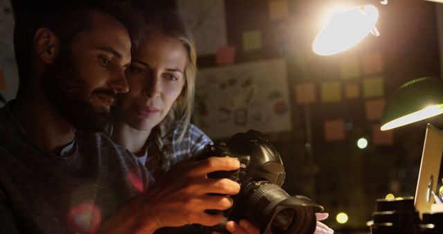 Photographers Reviewing Camera in Dimly Lit Studio at Night - Download Free Stock Images Pikwizard.com