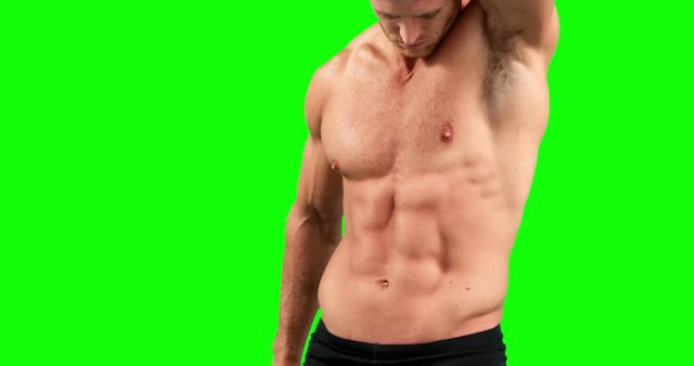 Fit male flexing his well-defined abs against a green screen backdrop, showcasing his muscular torso and athletic physique. Ideal for fitness promotions, motivational posters, workout videos, and health and wellness campaigns.