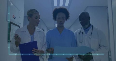 Medical Team Discussing Patient Records in Hospital Corridor