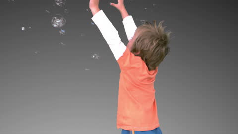 Joyful Boy Jumping and Playing with Bubbles in Joyful Moment