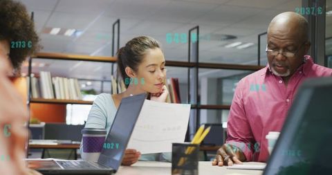 Collaborative team reviewing reports and analyzing data at modern open-plan office