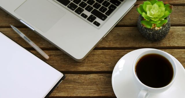 Office Workspace with Laptop, Coffee, Notebook, and Plant on Wooden Desk - Download Free Stock Images Pikwizard.com