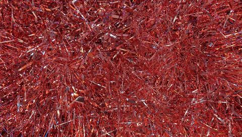 Glittering red tinsel macro texture reflective metallic foil sparkle background festive