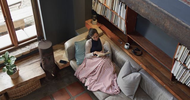 Woman Reading on Cozy Sofa in Modern Loft Apartment - Download Free Stock Images Pikwizard.com