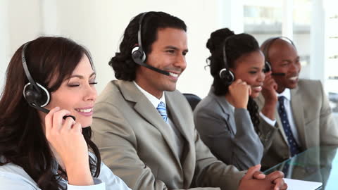Diverse Team Enjoys Call Center Tasks Wearing Headsets