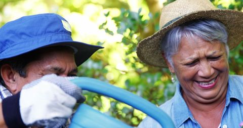 Happy Mature Gardeners Enjoying Sunny Day in Lush Garden