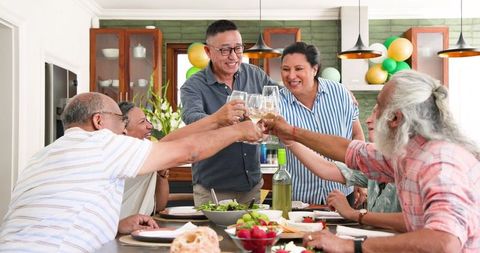 Diverse Group of Seniors Toasting at Dining Table Celebration