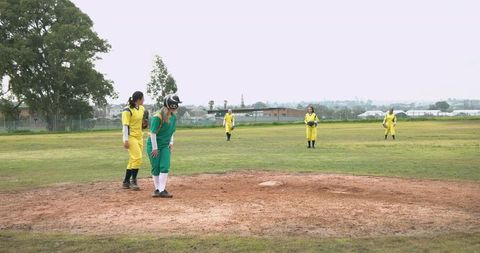 Female softball team practicing on open field