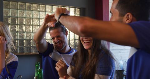 Excited sports fans celebrating at bar