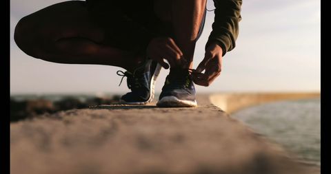 Athlete Tying Laces on Beach during Sunrise Jog - Download Free Stock Images Pikwizard.com