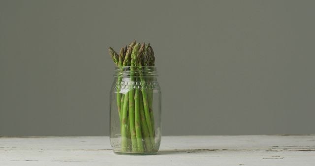 Image of fresh asparagus stalks in jar over grey background. fusion food, fresh vegetables and healthy eating concept.