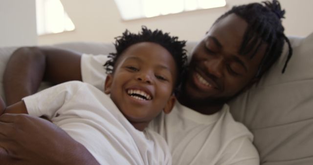 Smiling Father and Son Bonding on Couch - Download Free Stock Images Pikwizard.com