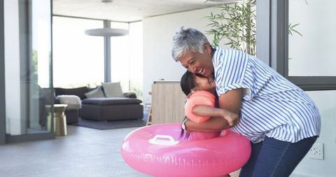 Joyful Moment Between Mother and Daughter With Pink Float