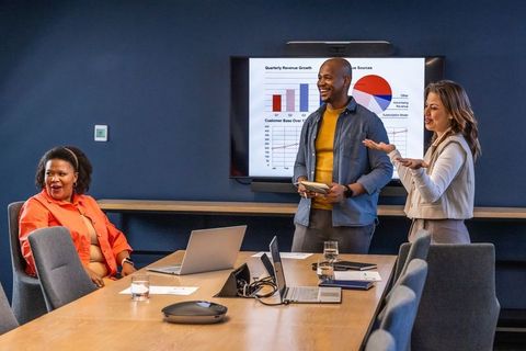 Diverse business team presenting strategy and analytics in modern boardroom meeting