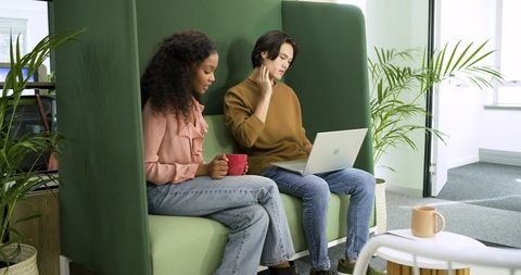 Colleagues Collaborating on Laptop in Office Lounge